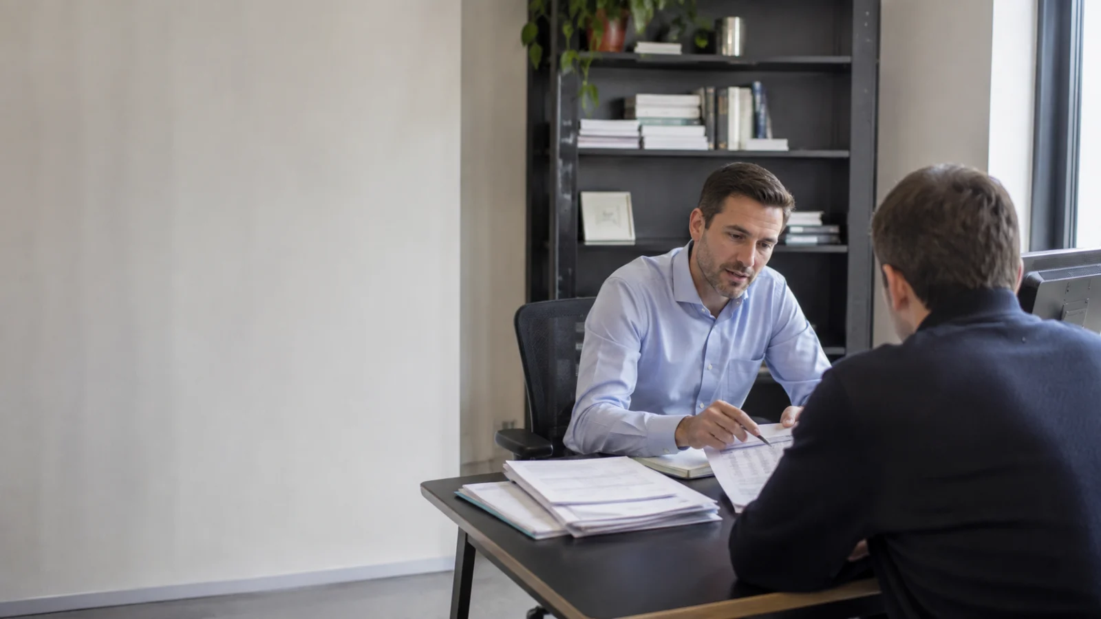 Un consulente finanziario presenta un piano concreto a una persona seduta di fronte a lui