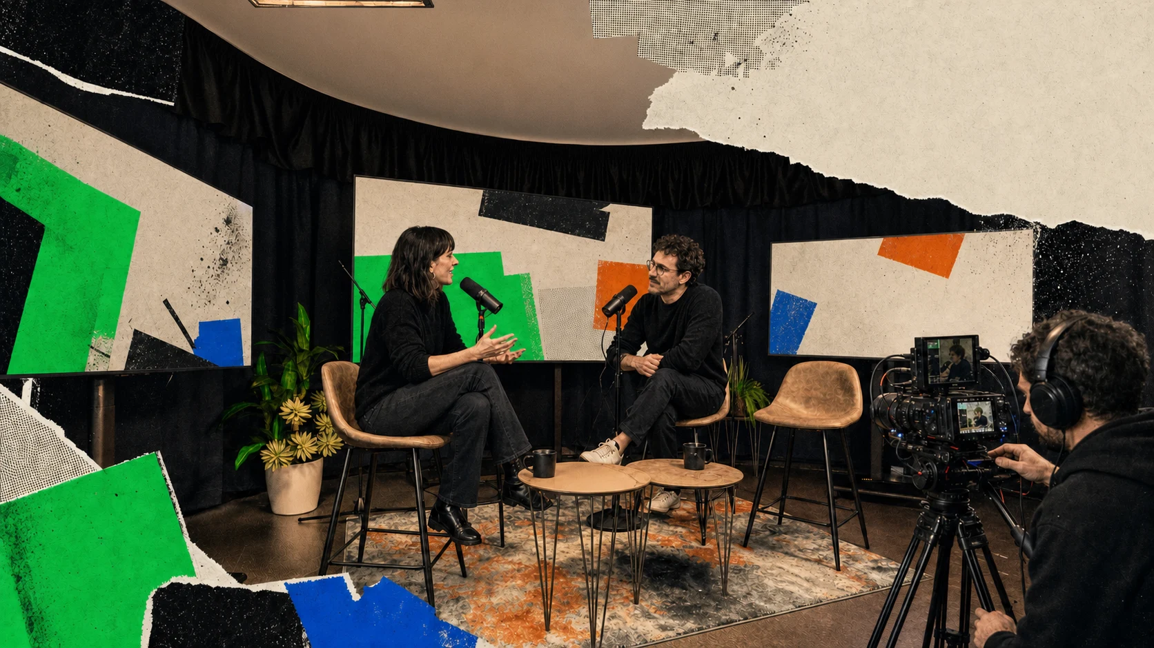 Due ospiti conversano ai microfoni mentre una camera registra nello studio